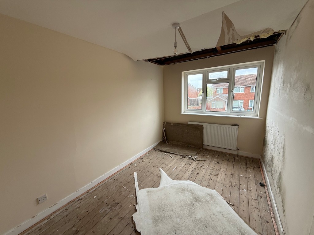 Lot: 114 - THREE-BEDROOM HOUSE FOR IMPROVEMENT AND REPAIR - Bedroom 1 with window to front and damage to the ceiling